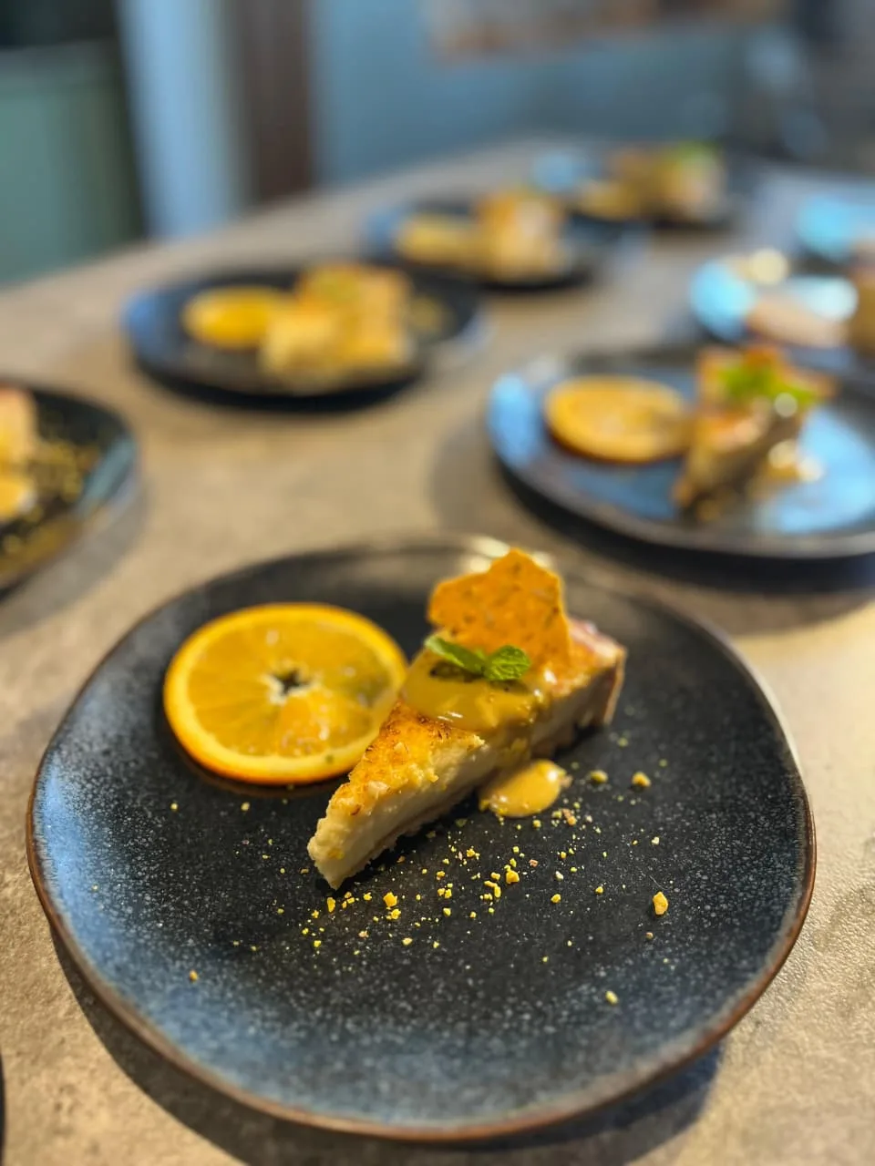 Pistachio cheesecake with citrus curd, candied orange and a pistachio tuile